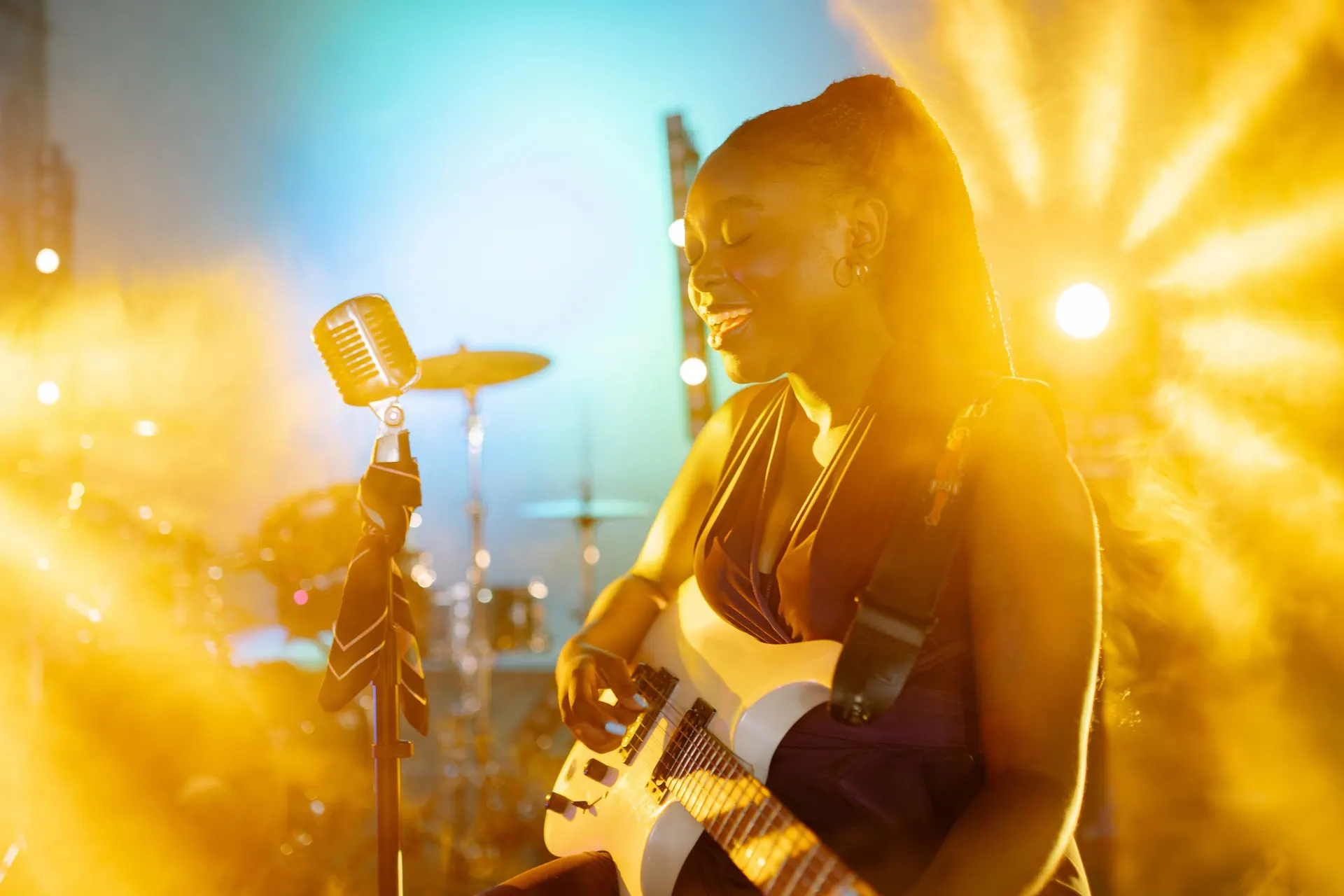 Imani Vey toca su guitarra blanca bajo una luz dorada